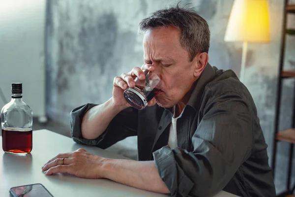 Concerned man feeling stressed drinking alcohol — Stock Photo, Image