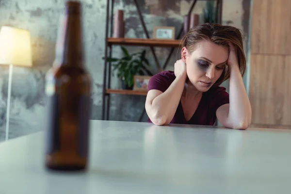 Betrunkene Frau mit blauem Auge trinkt Bier — Stockfoto