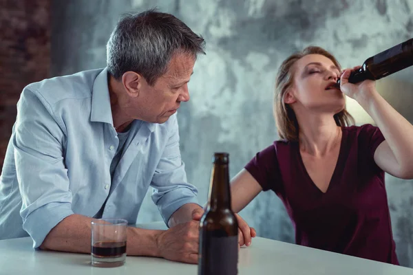 White collar worker feeling concerned looking at drunk wife