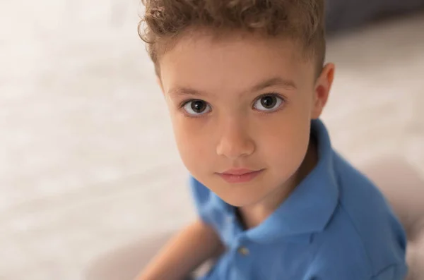 Bonito menino de olhos escuros brincando em casa — Fotografia de Stock