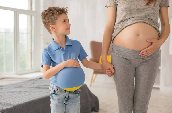 Yakışıklı kıvırcık çocuk hamile annesi elini alarak