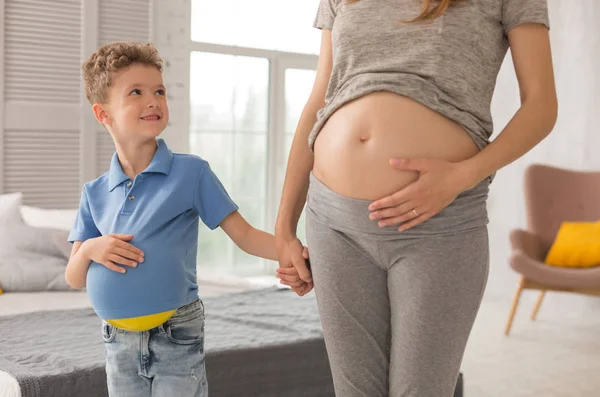小可爱的男孩看着他美丽的怀孕的母亲 — 图库照片