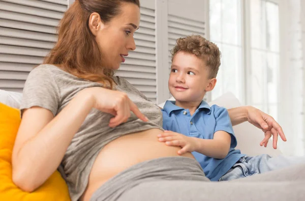 Grávida atraente mulher contando contos de fadas para o pequeno filho — Fotografia de Stock