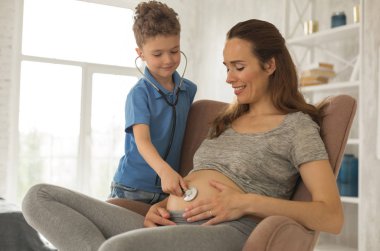 Küçük sevimli oğlu olmak gibi davranarak annesiyle oynayan doktor