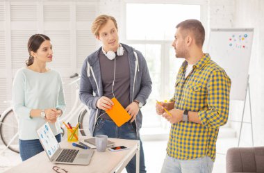 Büyük gelir. Ciddi üç meslektaşları fikirleri ve ayakta ile geliyor