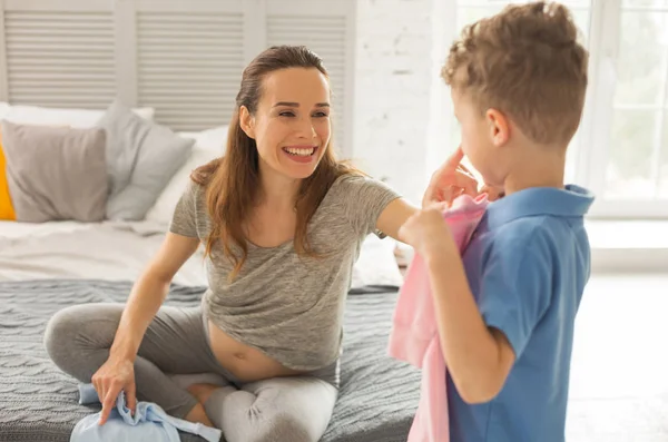 Gülümseyen hamile kadın Çift Kişilik Yatak birçok yastık ile oturup...