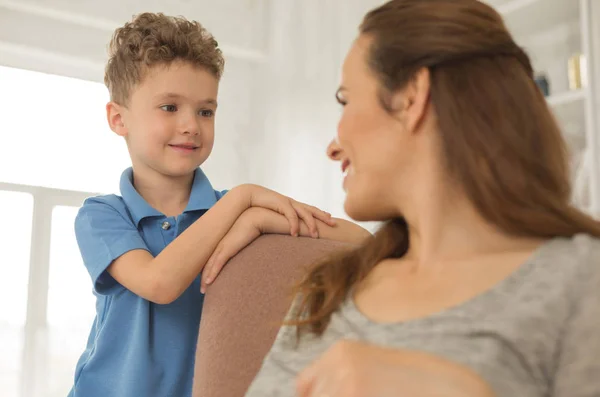 Verantwortungsbewusster kleiner Sohn blickt auf seine schwangere Mutter — Stockfoto