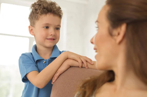 Kleiner gehorsamer Sohn hört seiner schönen Mutter zu — Stockfoto