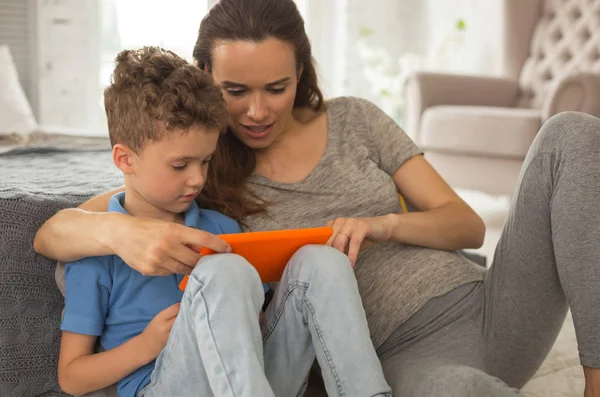 Affascinante attesa donna guardando le foto con il figlio più giovane — Foto Stock