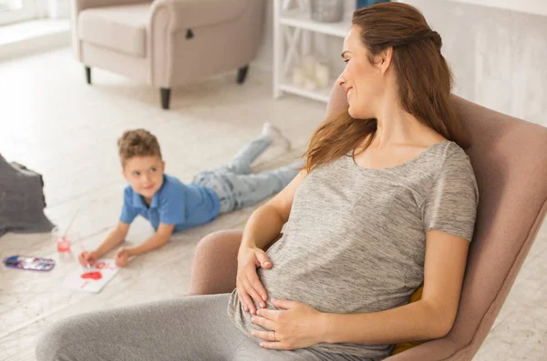 Embarazada sintiéndose aliviada mirando dulce hijo — Foto de Stock