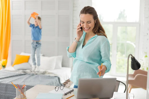 Diseñador remoto embarazada hablando por teléfono con el cliente —  Fotos de Stock