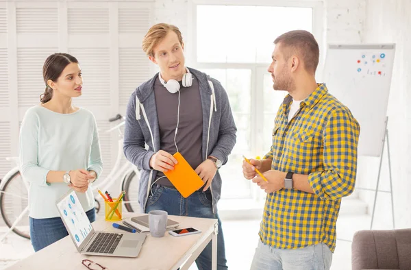 Büyük gelir. Ciddi üç meslektaşları fikirleri ve ayakta ile geliyor