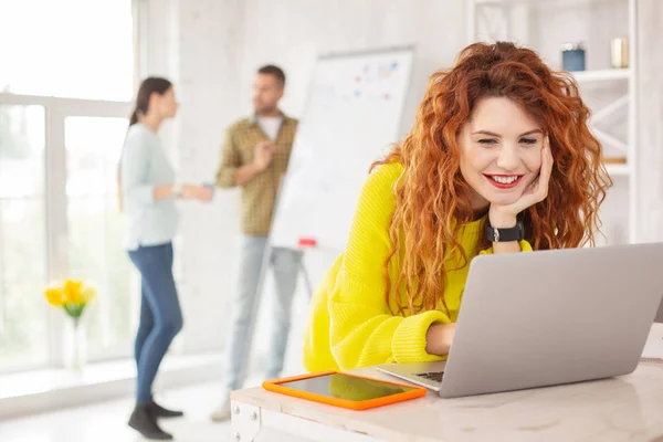 Jolly kvinnlig anställd arbetar med laptop — Stockfoto