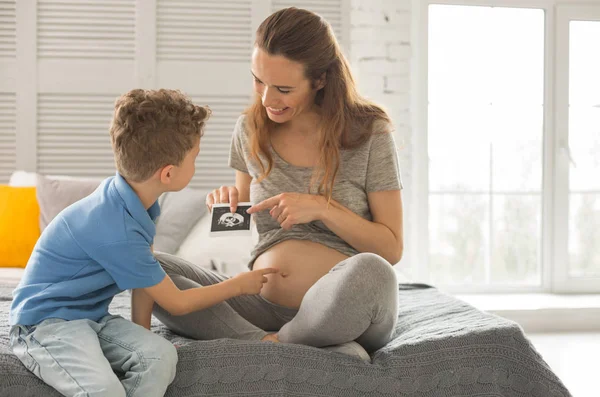 Pregnant woman showing ultrasound investigation of future baby — Stock Image Pregnant woman showing ultrasound investigation of future baby Royalty Free Stock Images