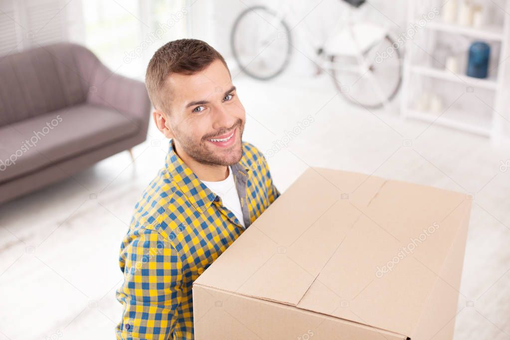 Pleased positive man entering new apartment