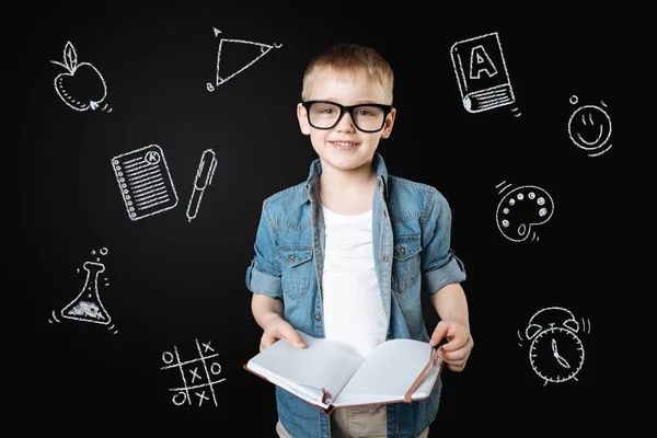 Clevere Schülerin hält Notizbuch in der Hand und bereitet sich auf den Unterricht vor — Stockfoto