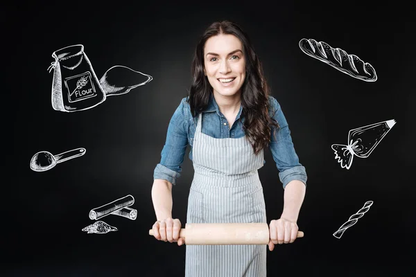 Positieve vrouw met een deegroller terwijl het maken van brood — Stockfoto