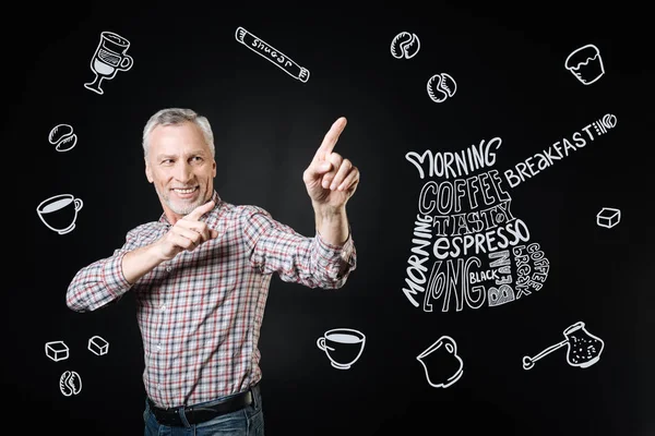 Positive owner of the cafe smiling and pointing to a new tasty coffee — Stock Photo, Image