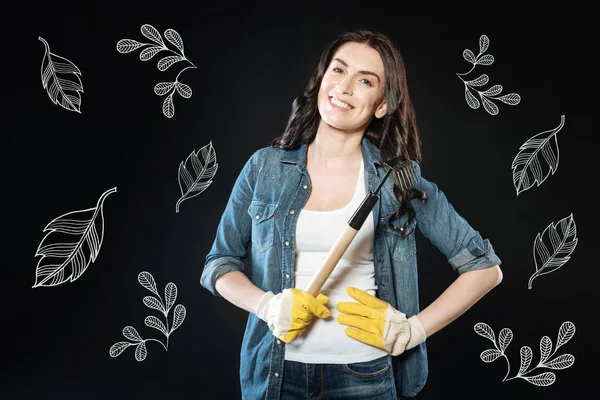 Cheerful woman standing with rakes while working in the garden — Stock Image Cheerful woman standing with rakes while working in the garden Stock Picture