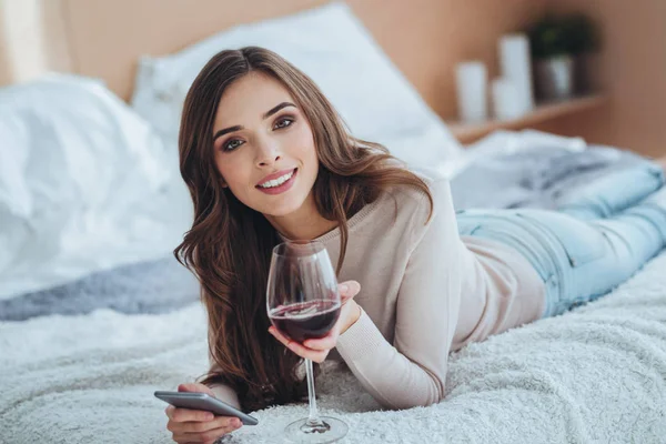 Bir bardak şarap tutan neşeli güzel kadın