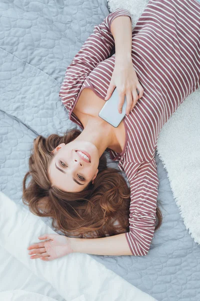 Радісна щаслива жінка відпочиває на ліжку — стокове фото