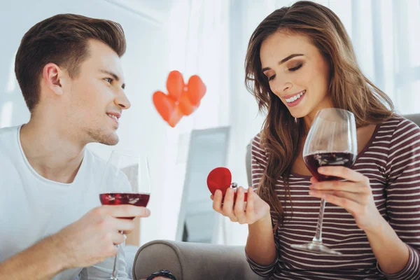 Mujer atractiva feliz sosteniendo un anillo de compromiso — Foto de Stock