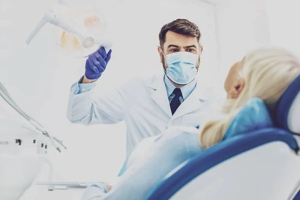 Blij tandarts behandeling van zijn patiënt — Stockfoto