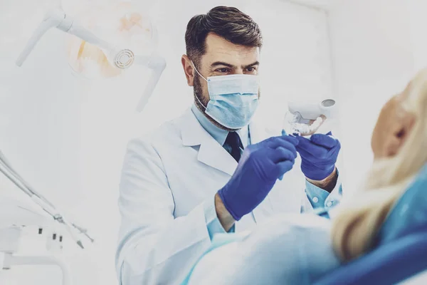 Handsome stomatologist demonstrating artificial jaw — Stock Photo, Image