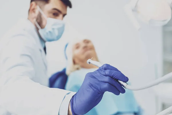 Geconcentreerde brunette man aan het werk in tandheelkundige kabinet — Stockfoto