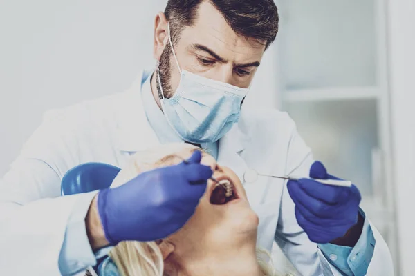 Estomatólogo atento examinando a su paciente —  Fotos de Stock