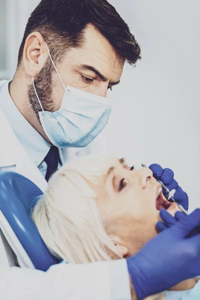 Retrato de dentista profesional que trata al paciente —  Fotos de Stock