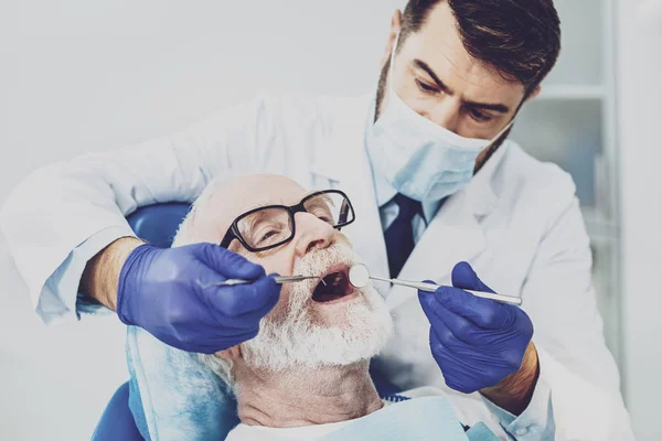 Medico attento facendo controllo dei denti — Foto Stock