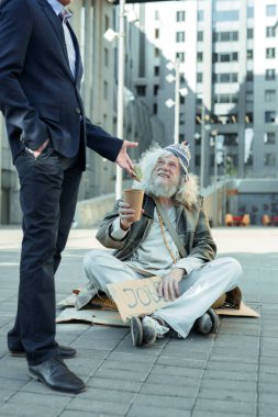 İş için soran işareti ile oturan yaşlı hippi adam