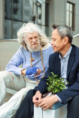 Hippi adam yabancı konuşurken boncuk kolyesi