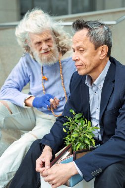 Kötümser üzgün adam yanında oturan hippi ilham