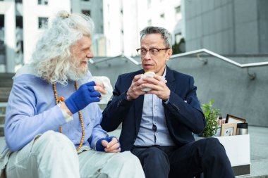 İki yaşlı adam et Burger ısırma