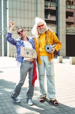 Gülümseyen çiçek-çocuklar yüksek sesle şarkı kot giyen