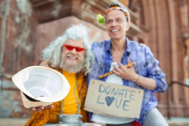 İki sokak müzisyenleri paralarını koymak için şapka veren gülümseyen