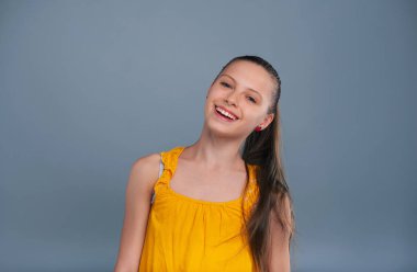 Başını eğme ve gülümseyen neşeli genç kız