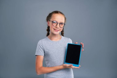 Sevimli Genç kız mavi tablet gösteren gözlük