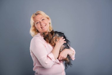 Mutlu orta yaşlı bir kadın köpeğiyle sarılma