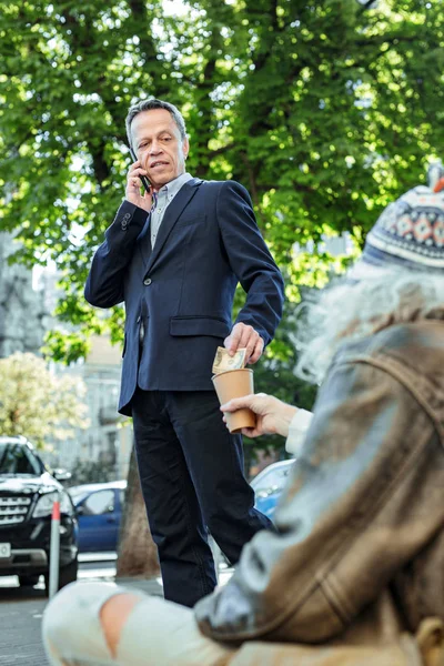 Engineer in black suit giving some money to street person — Stock Photo, Image