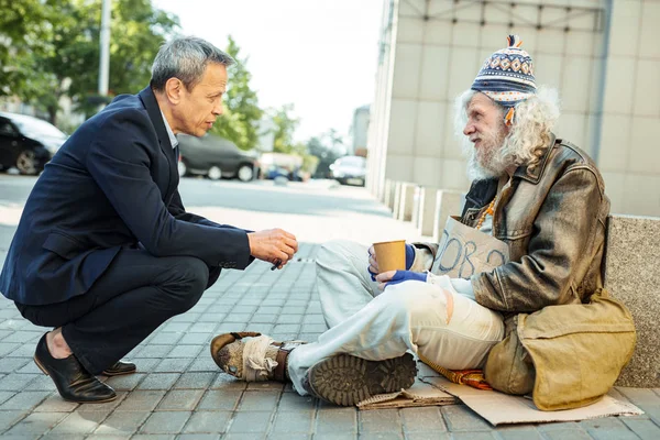 Helpful office worker asking street person about needed food — Stock Photo, Image