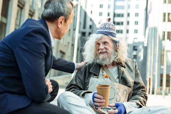 Bra affärsman röra axeln av dålig flykting — Stockfoto