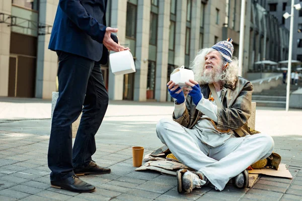 Goedhartig zakenman helpen daklozen op zijn weg naar huis — Stockfoto