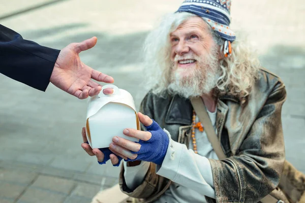 Rua hippy homem vestindo jaqueta de couro velho recebendo comida — Fotografia de Stock