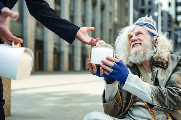 Благотворитель поощряет других людей давать еду бездомным — стоковое фото