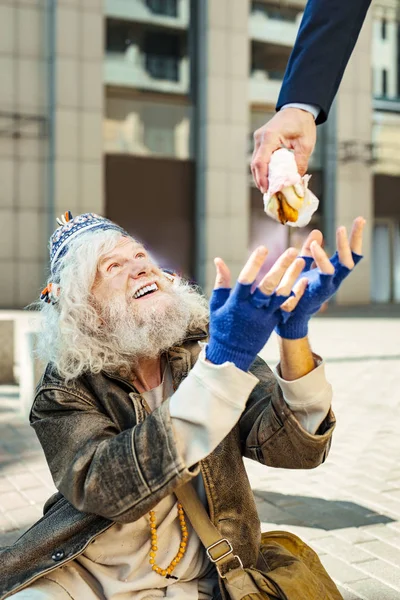 Hajléktalan férfi feeling very happy, élelmiszer-nézett — Stock Fotó
