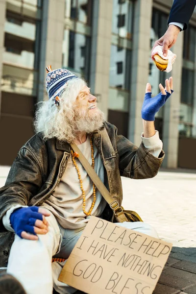 Stranger giving big meat burger to smiling relieved homeless — Stock Photo, Image