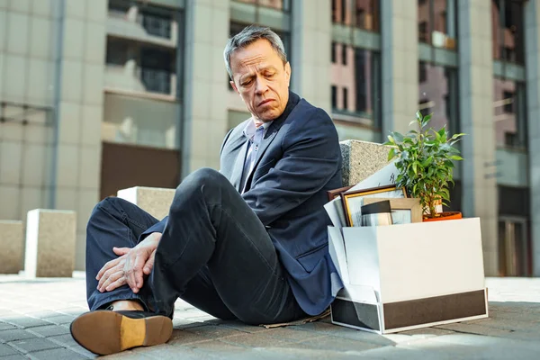 Hombre despedido mirando la caja con cosas personales — Foto de Stock